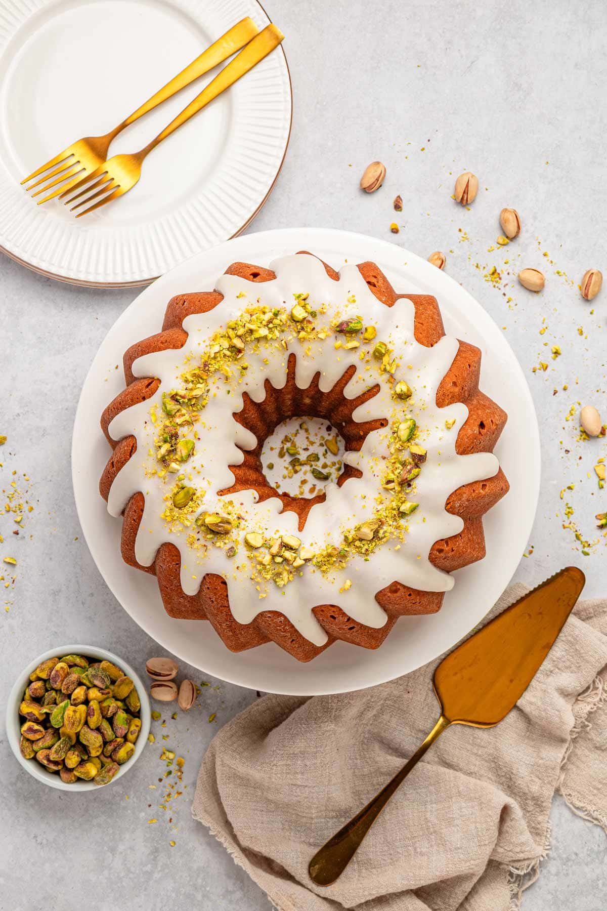 overhead view of a pistachio bundt cake with thick vanilla glaze and chopped pistachios.