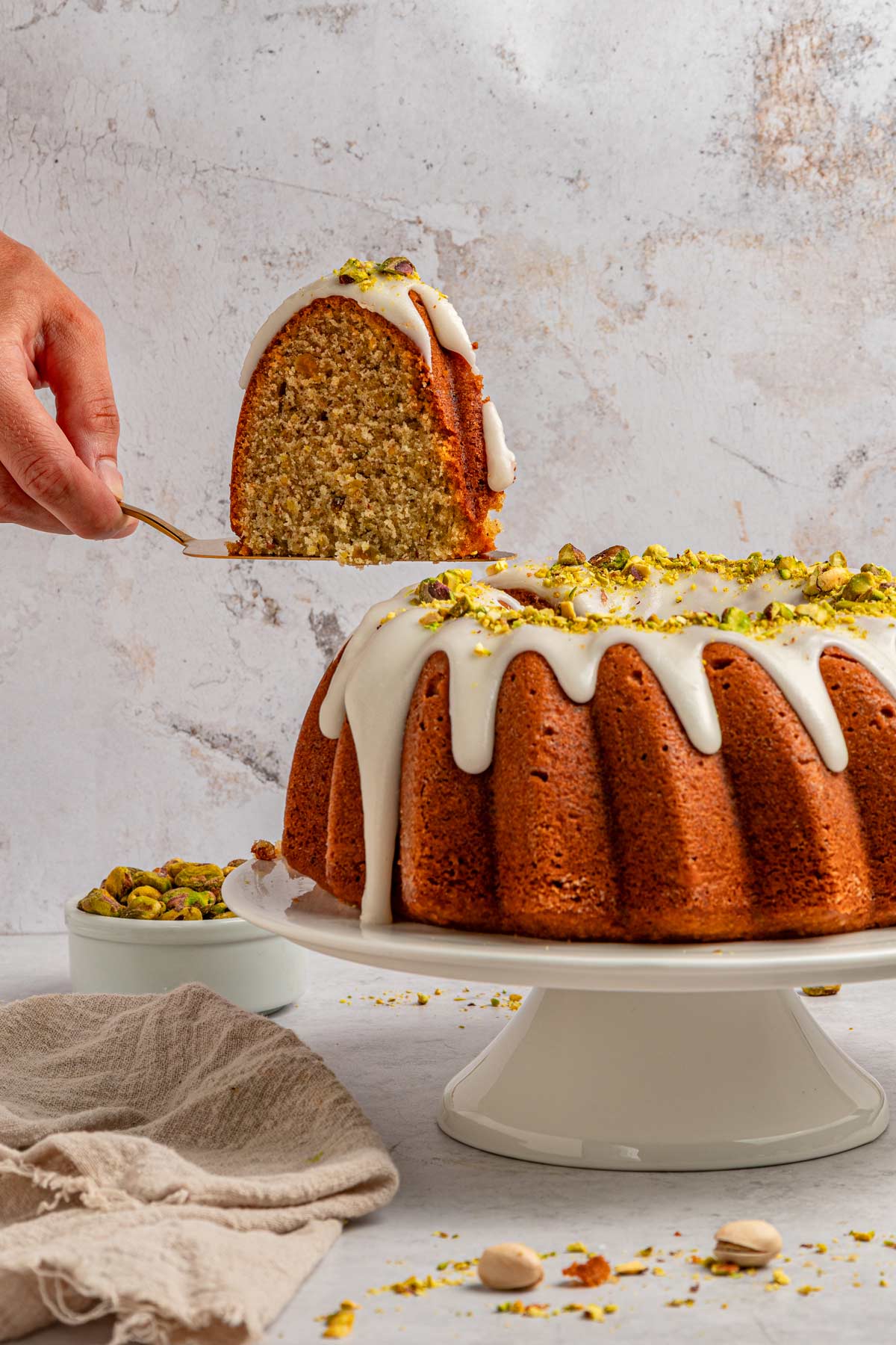 slice of pistachio bundt cake being lifted away from the cake.