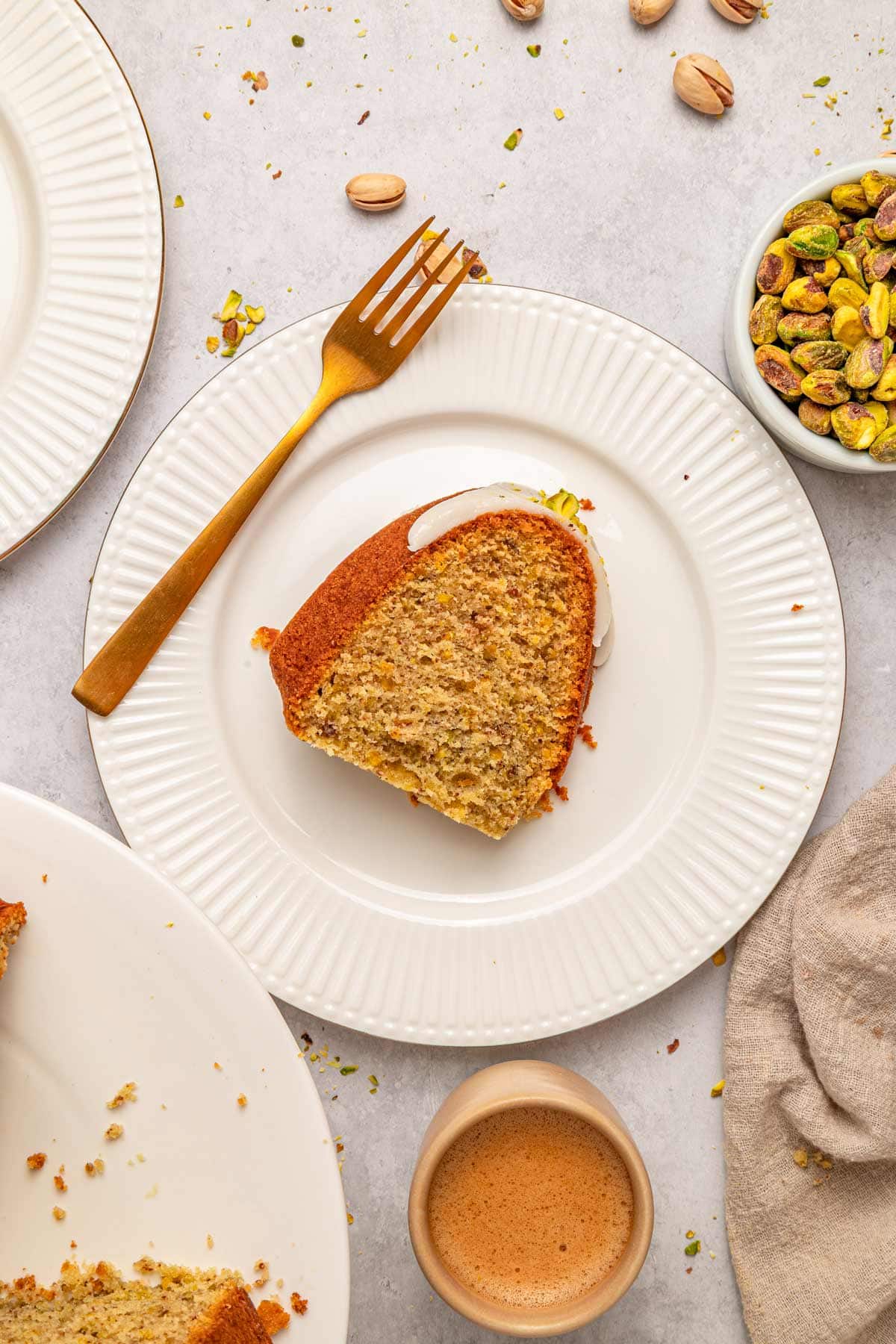 single slice of pistachio bundt cake on a white dessert plate.