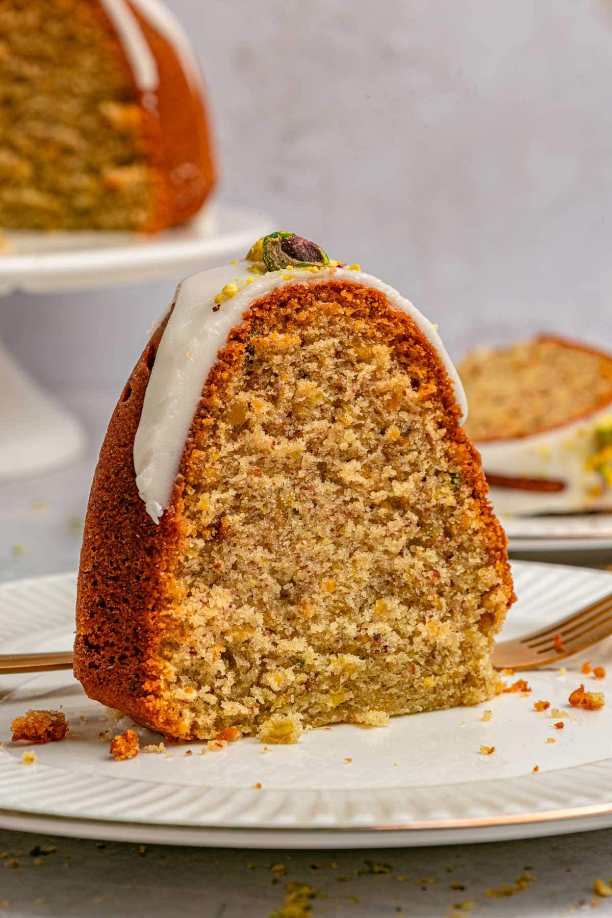 close up view of a slice of pistachio cake showing the interior crumb.