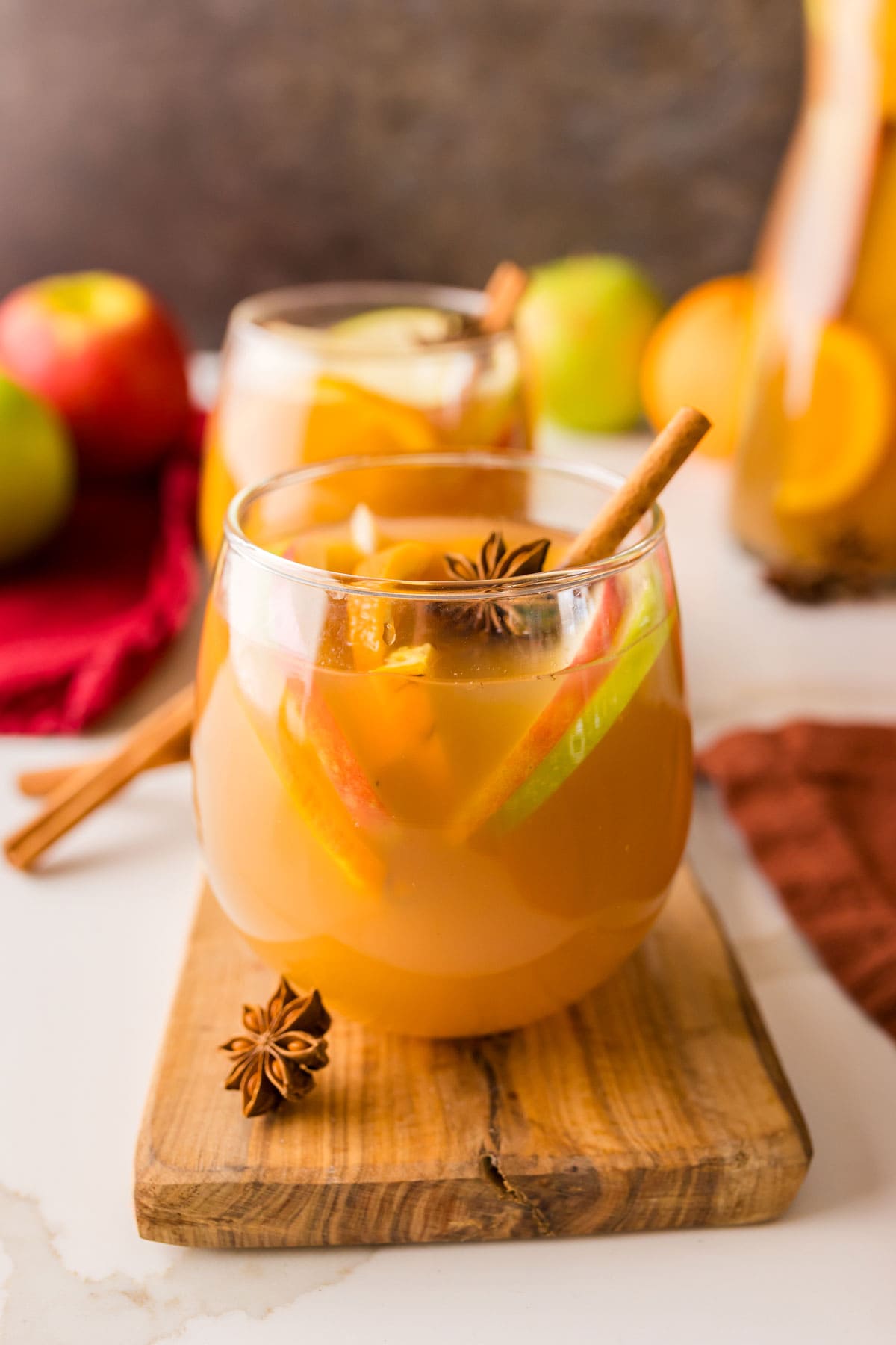 glass of apple cider sangria on a wooden plank.