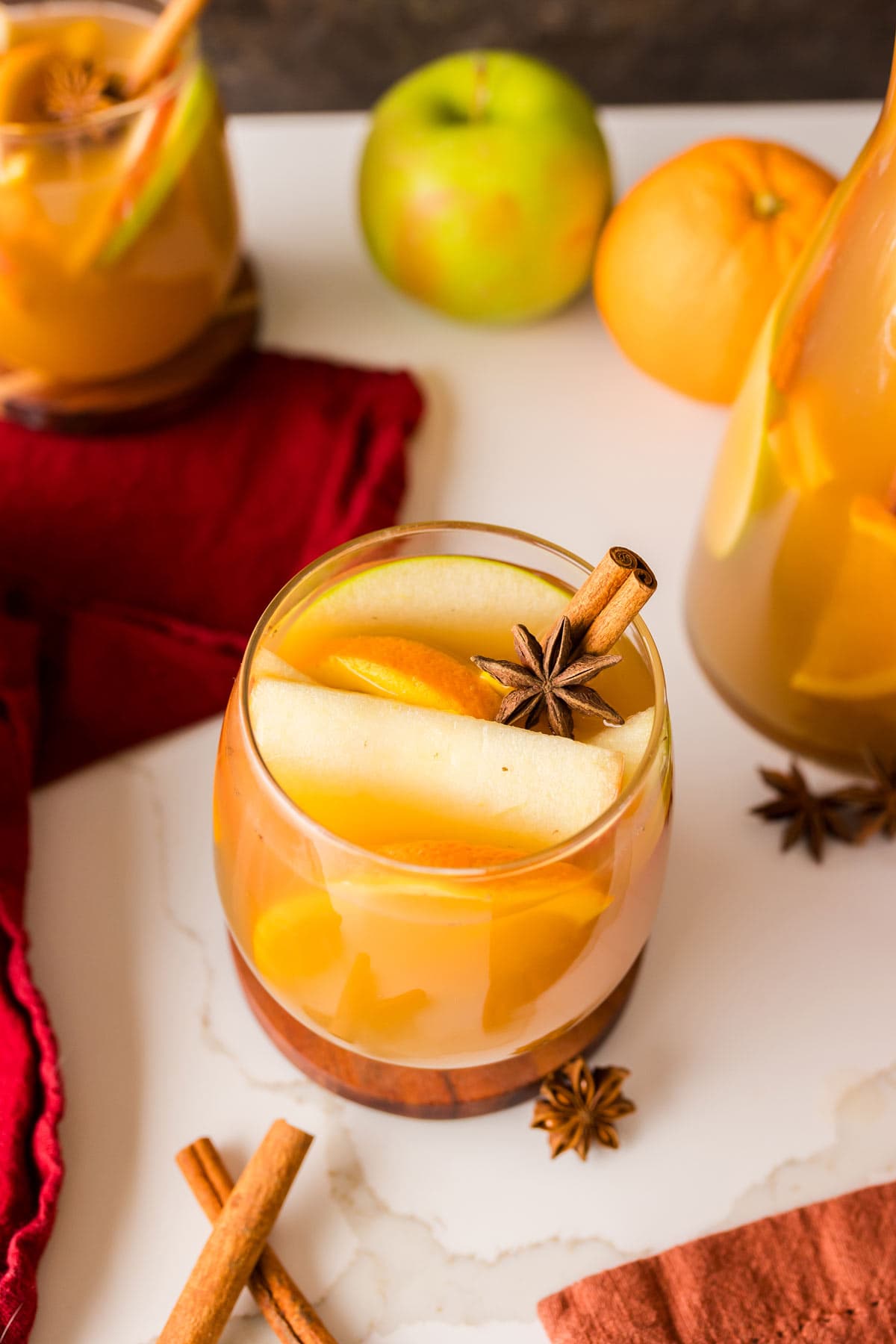 glass filled with sangria with fall fruits and star anise.
