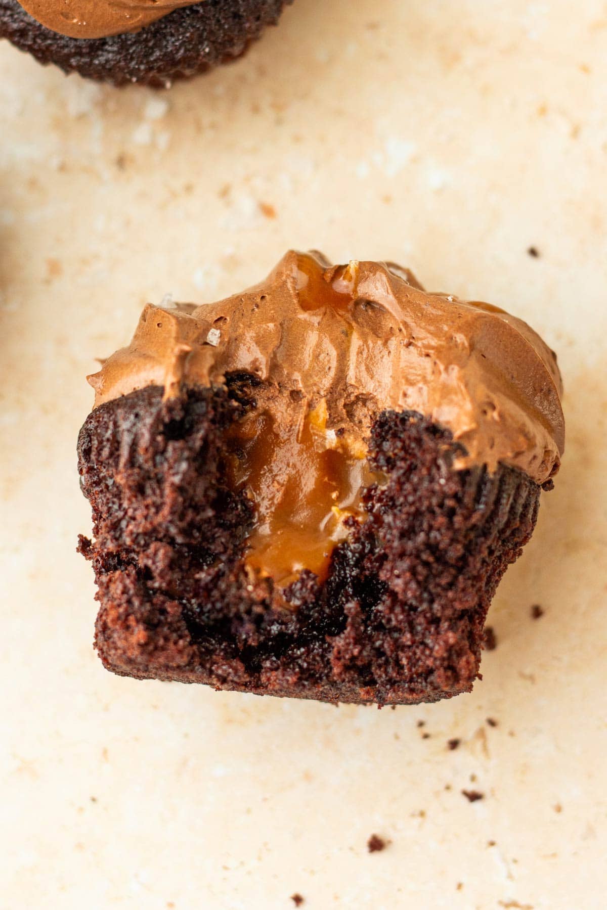 side view of a cupcake cut in half showing the caramel filling inside.