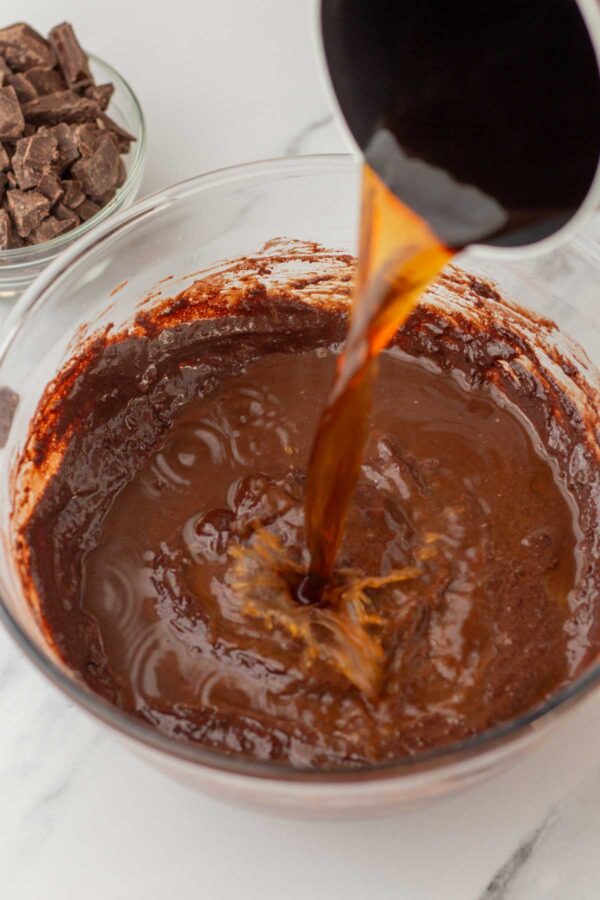 pouring hot coffee into chocolate cake batter.