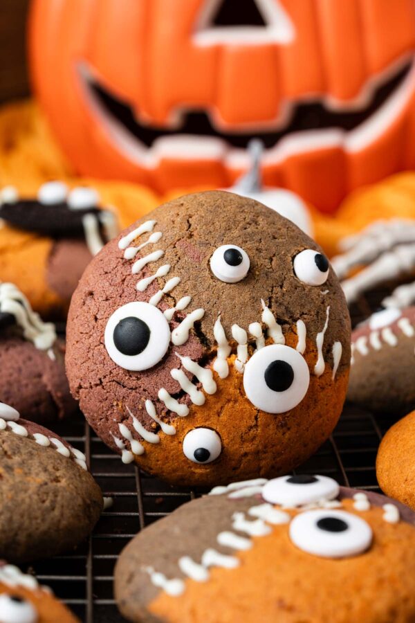 three colored cookie with monster eyes and white chocolate stitches.