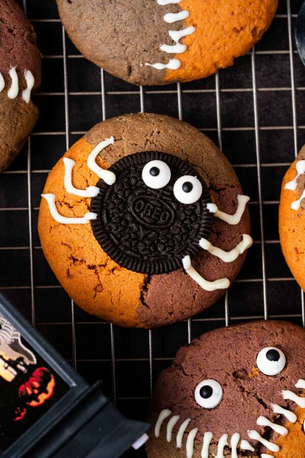 Halloween cookies decorated to look like spiders with candy eyeballs and candy melt legs.