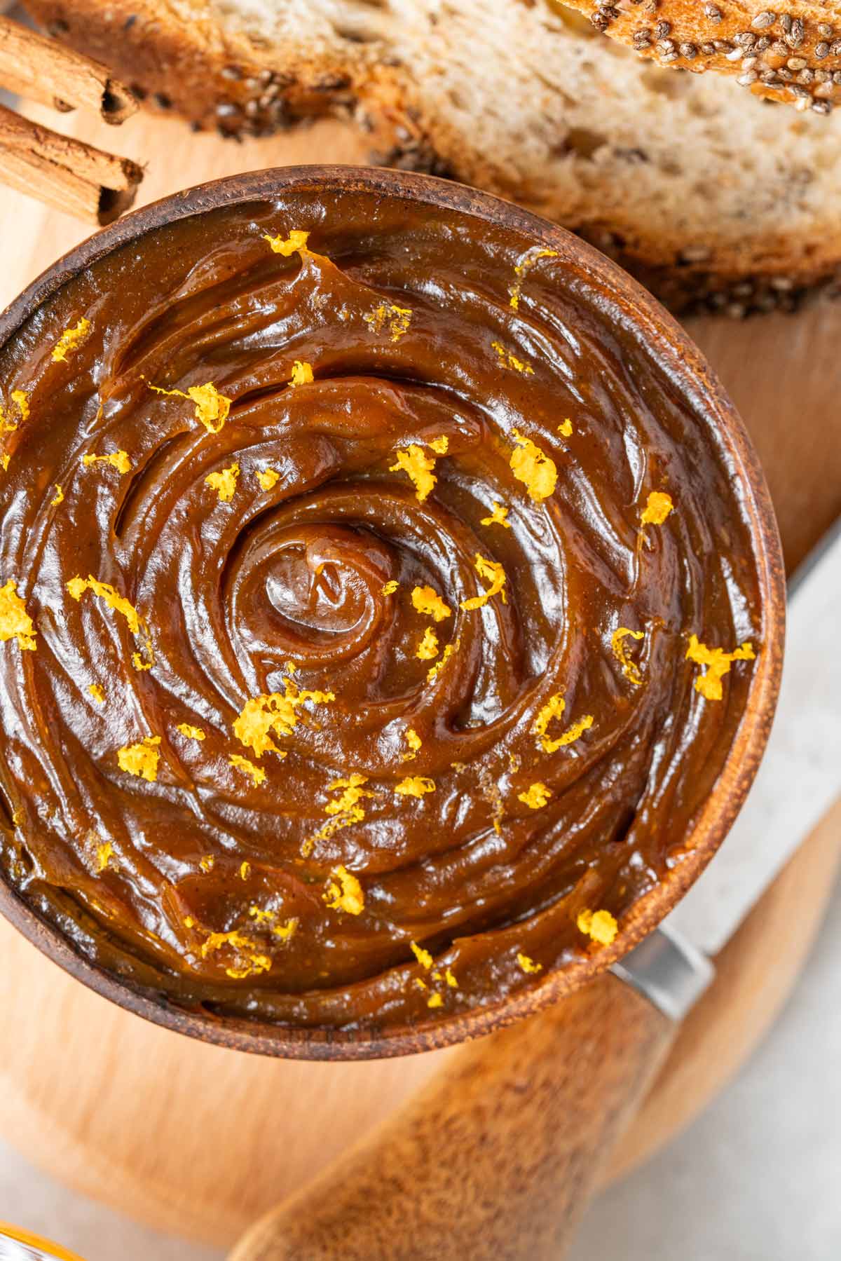 bowl filled with thick glossy pumpkin butter topped with orange zest.