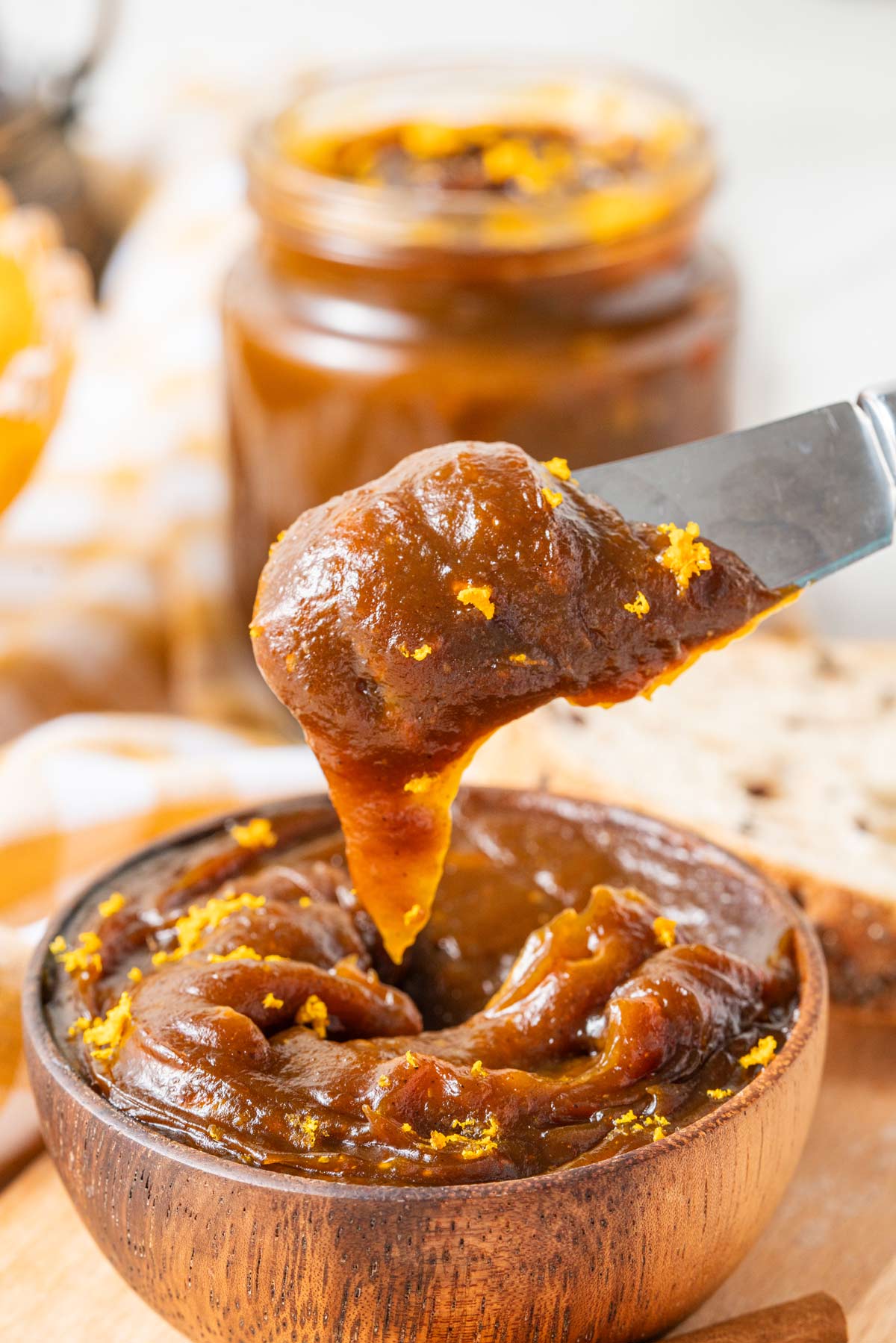 thick pumpkin butter scooped up on a knife.