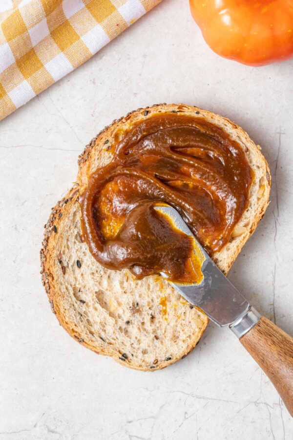 spreading pumpkin butter on a piece of bread.