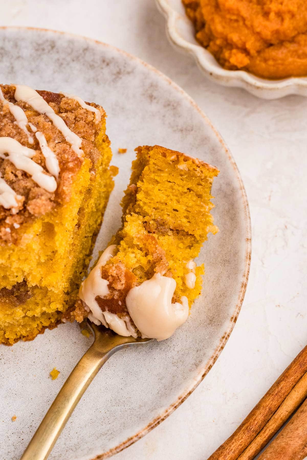 forkful of pumpkin coffee cake on a dessert plate.