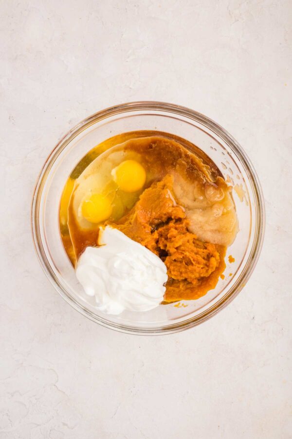 wet ingredients to make a cake in a glass mixing bowl.