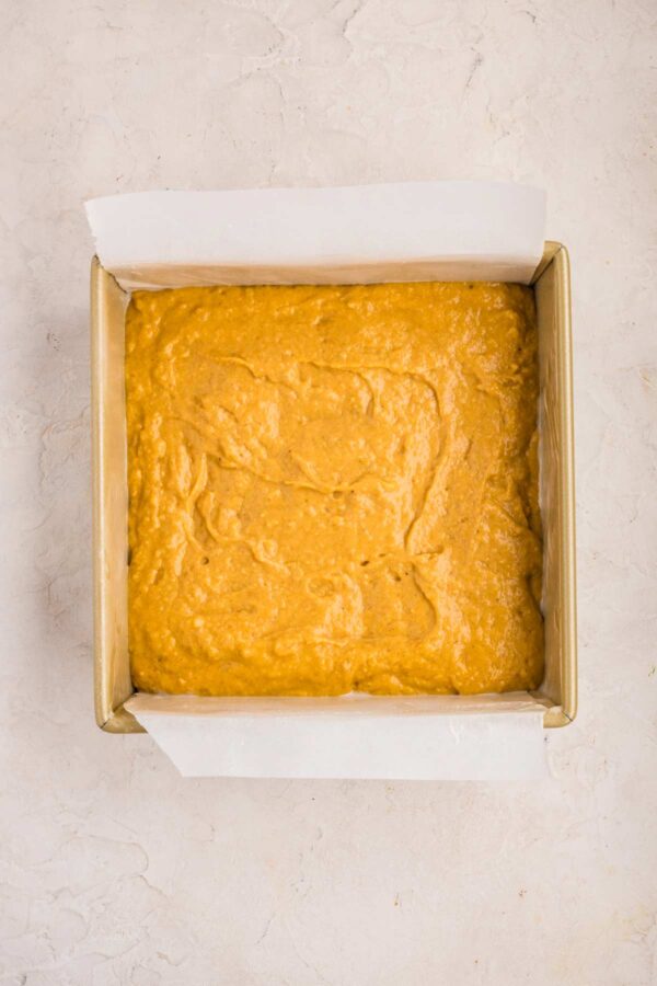 pumpkin coffee cake batter in a square pan.