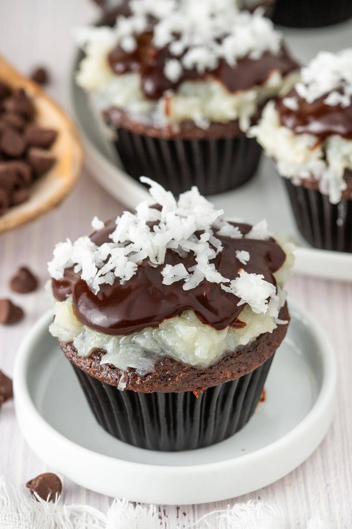 chocolate cupcake topped with a layer of gooey coconut and a drizzle of chocolate ganache.
