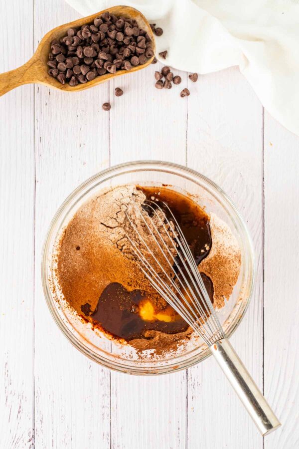 whisking together ingredients to make chocolate cupcakes.