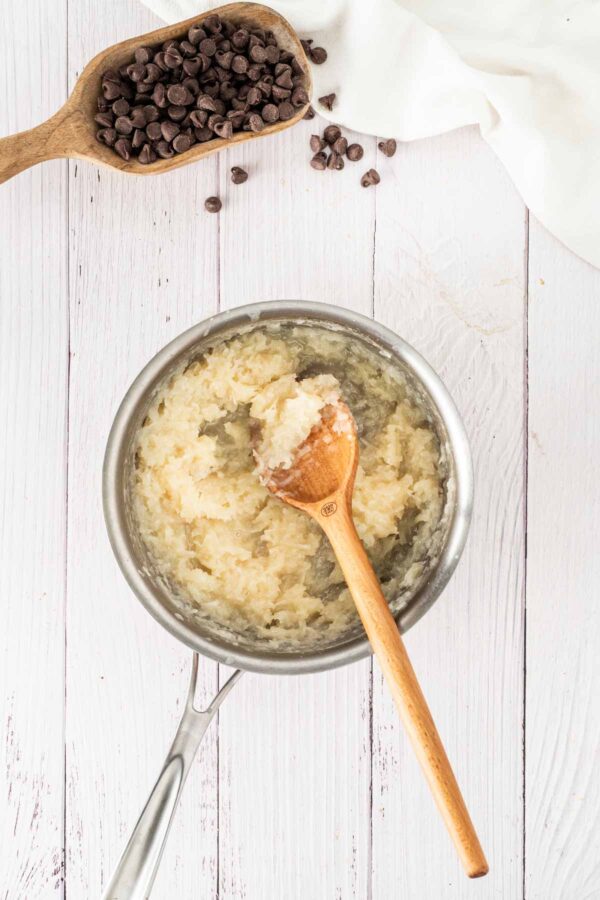 mixing shredded coconut and condensed milk in a mixing bowl.