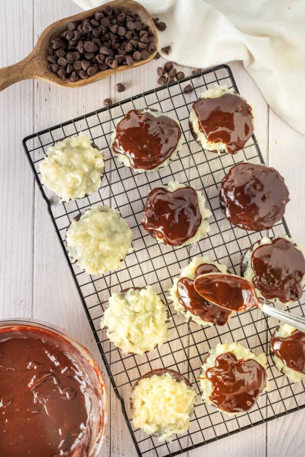 spooning ganache over chocolate coconut cupcakes.