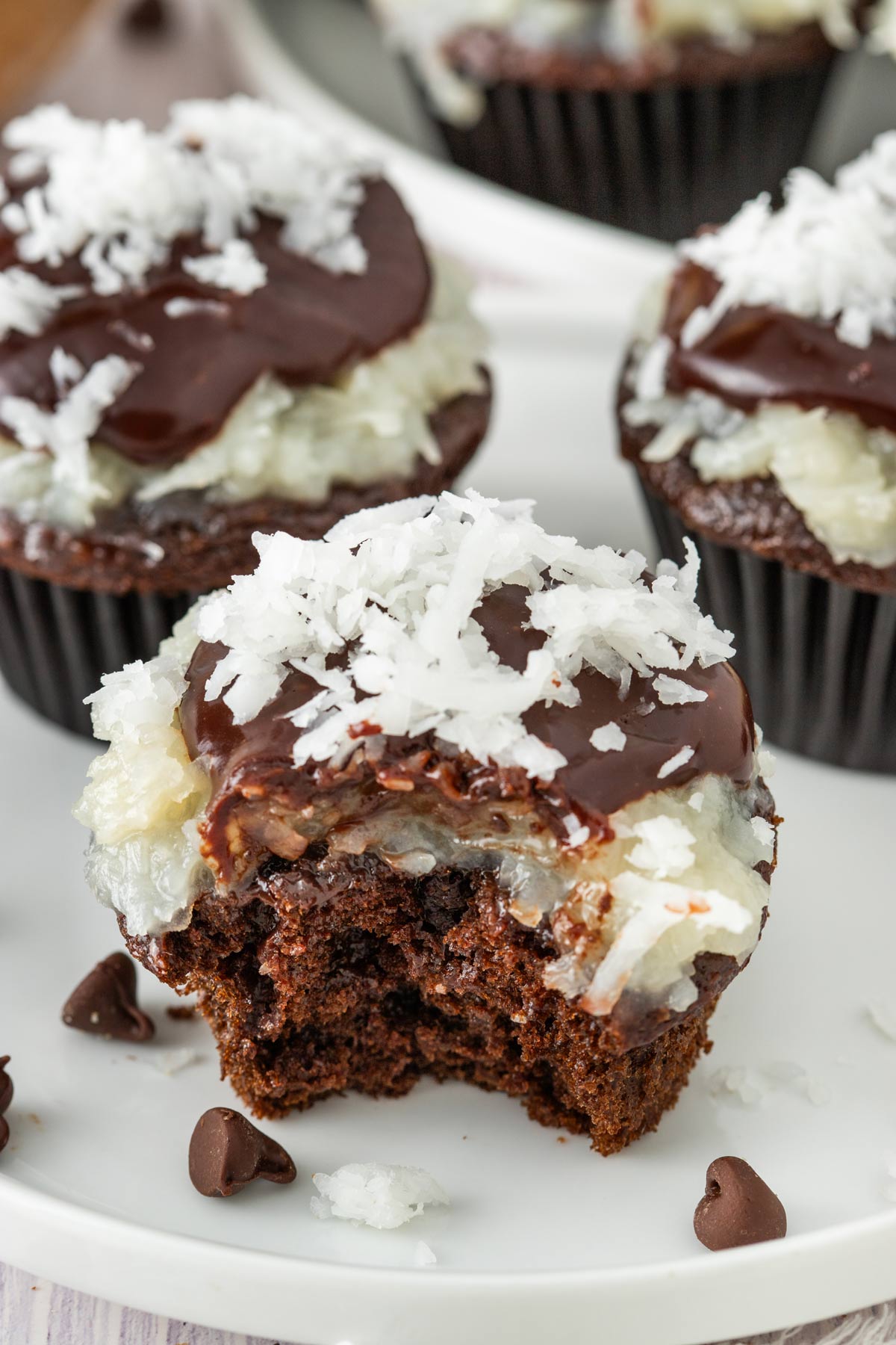 chocolate coconut cupcake with a bite taken out showing the fluffy interior.